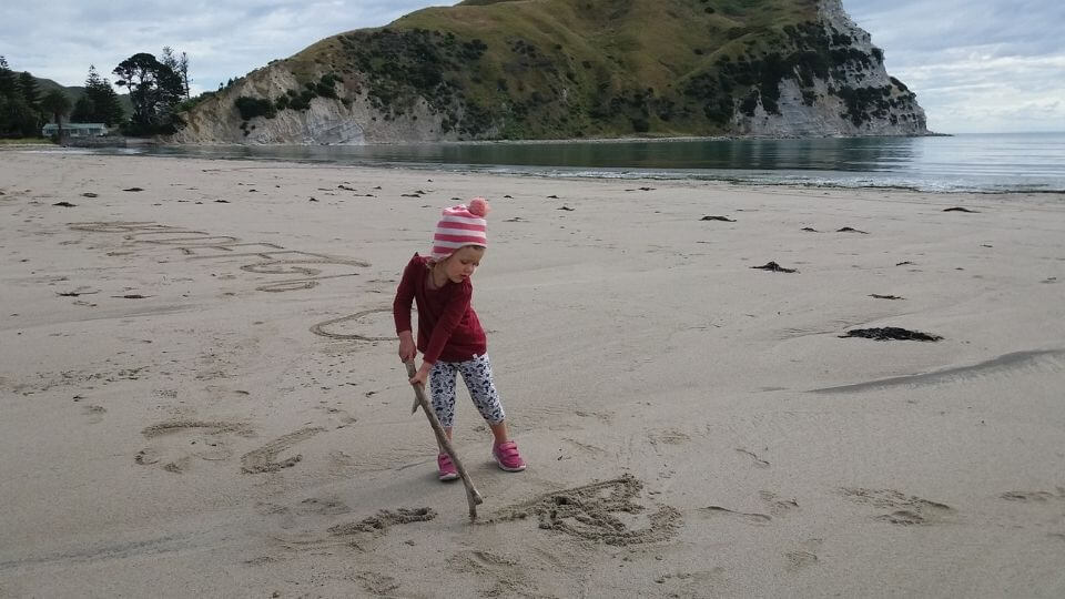 Things to do between Napier and Gisborne-Mahia Peninsula Beaches-Ayla playing in sand
