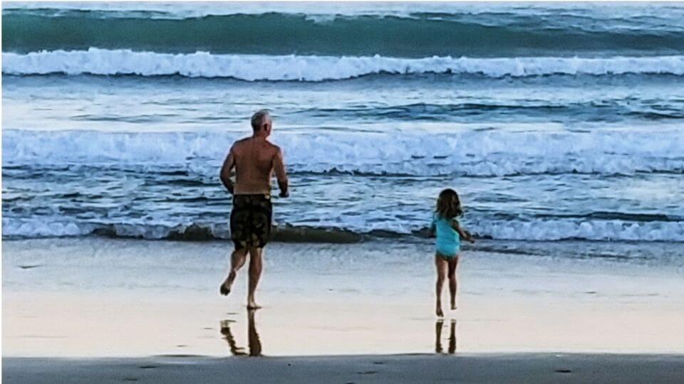 things to do in Gisborne-surf, swim, splash in the waves-Colin and Ayla running into the water