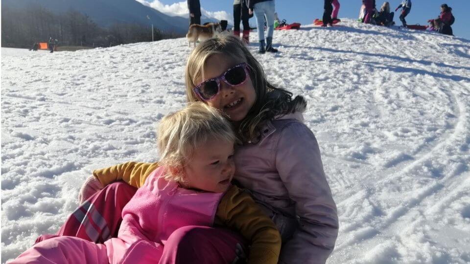 Top things to do in Bansko with kids in the winter time-sledding-Ayla and Romy on sled