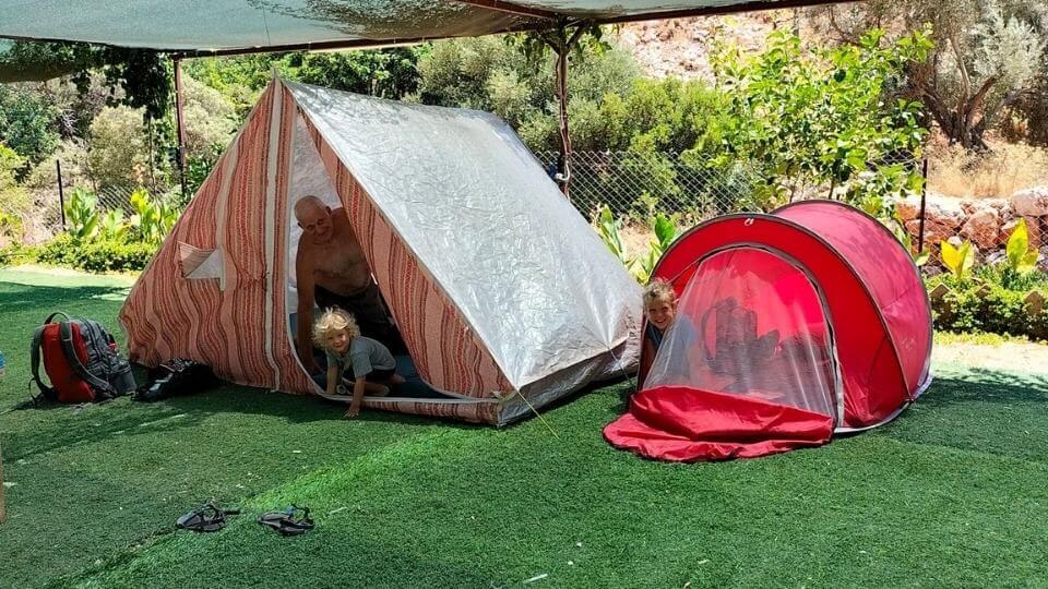 Camping is one of the fun things to do in Kas-Ayla, Romy, and Colin peeking out of tents