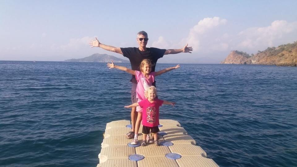 Drive around the fethiye peninsula and enjoy the natural beauty-Bill, Ayla, and Romy stretching their arms out on the jetty