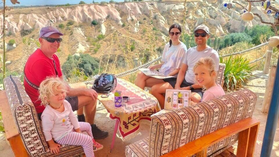 Enjoying a second Turkish breakfast with the family overlooking a canyon of rocks in Cappadocia after visiting Uchisar castle