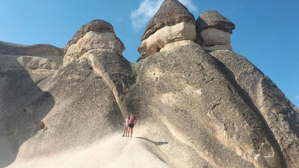 Things to do in Cappadocia-Monks valley-Ayla and Elly drawfed by the giant rock formations behind