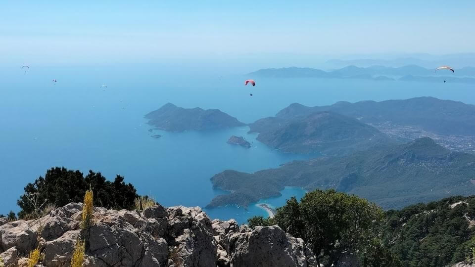 View from the top of Babadag in Fethiye with paragliders in the sky making their way down to oludeniz