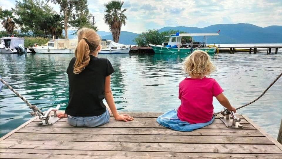 Ayla and Romy sitting on a pier at the Akyaka river mouth during our Turkey to Georgia road trip