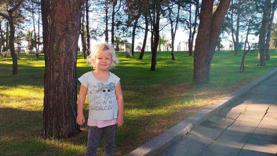 Exploring the Boulevard is one of the fun things to do in Batumi, Georgia-Romy standing next to a green space on the boulevard.