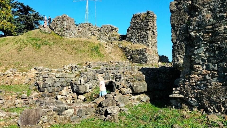 Visit the Petra Fortress if you are looking for things to do in Batumi-Romy exploring the hillside ruins on a sunny, blue-sky day.