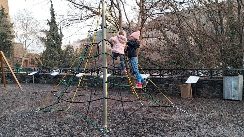 Ayla and Romy in a climbing frame at the botanical gardens playground in Tibilisi