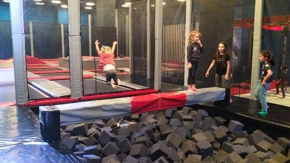 Romy jumping off a beam into a foam pit in the trampoline area at Tibilisi's City Mall