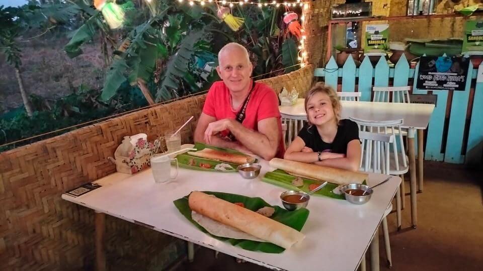 Ayla and Colin eating dosas, a traditional South Indian food, at Mrs Morgans in Anjuna, North Goa.