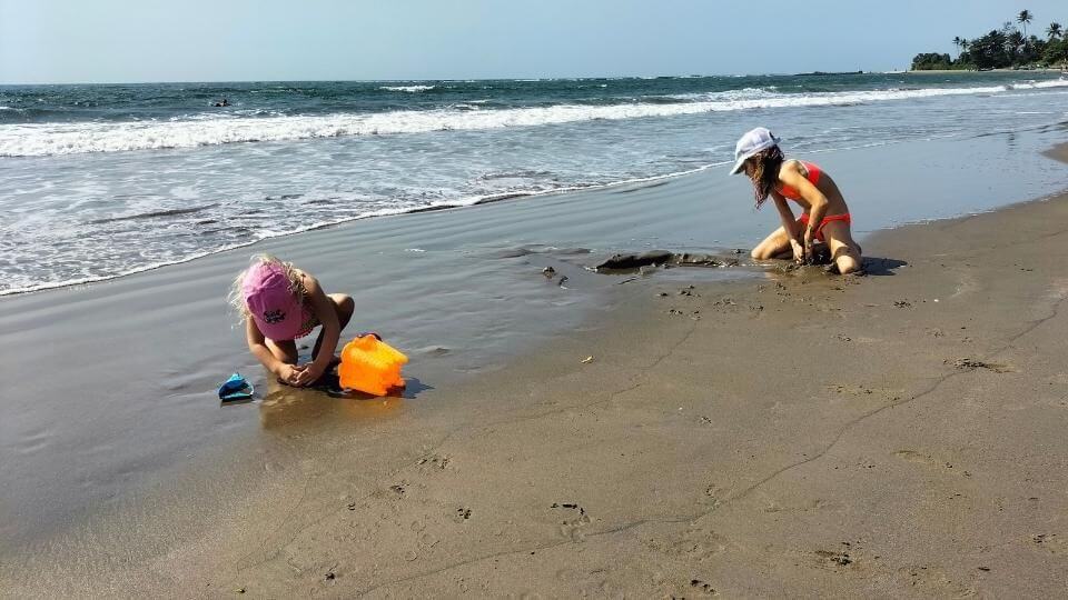 Ayla and Romy enjoying digging in the sand at Morjim beach in North Goa, India.