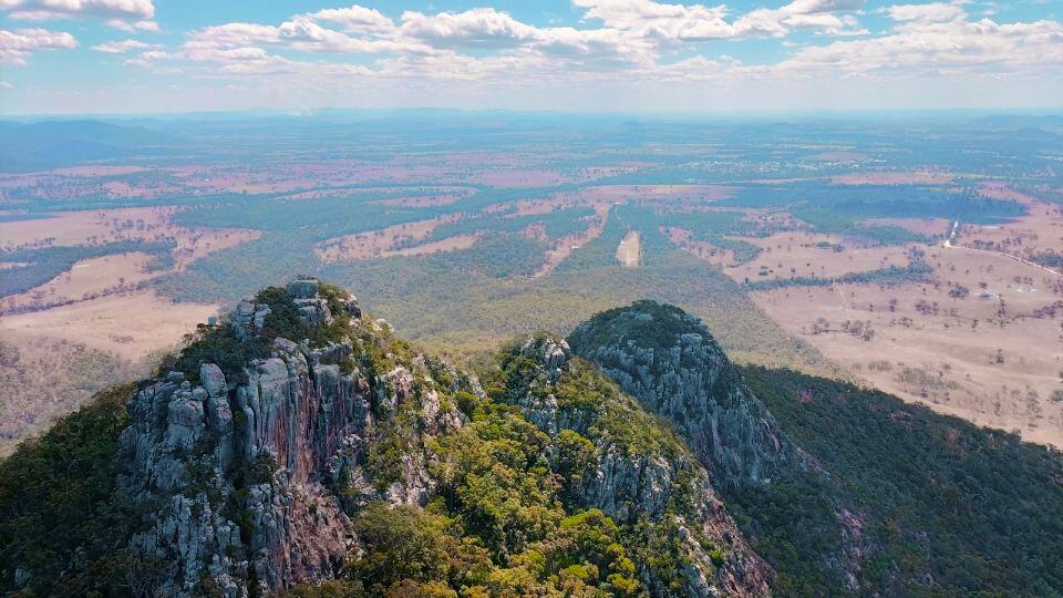 A breathtaking view of rocky mountain peaks and the plains beyond from the Mount Walsh summit, central Queensland.