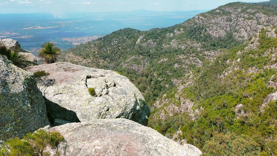 A view of rocky outcrops and rocky green hills from the top of Mount Walsh in central Queensland.