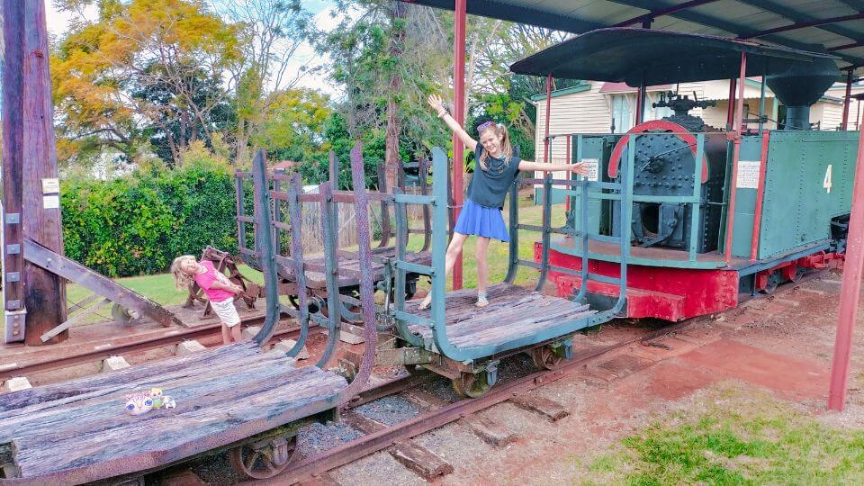 Ayla and Romy play on old train carriages at the Childers Historic Complex.