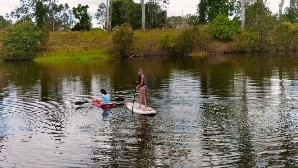 Ayla and friend on kayaks and stand up paddles boards at Smiths Crossing near Bundaberg.