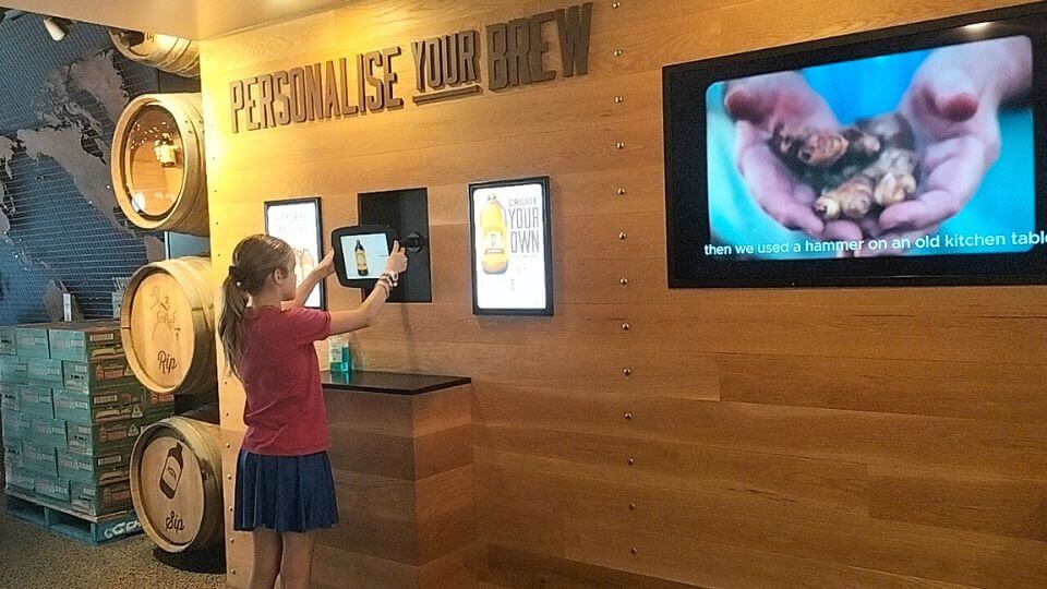 Ayla uses an iPad at the Bundaberg Barrel to make personalized stickers.