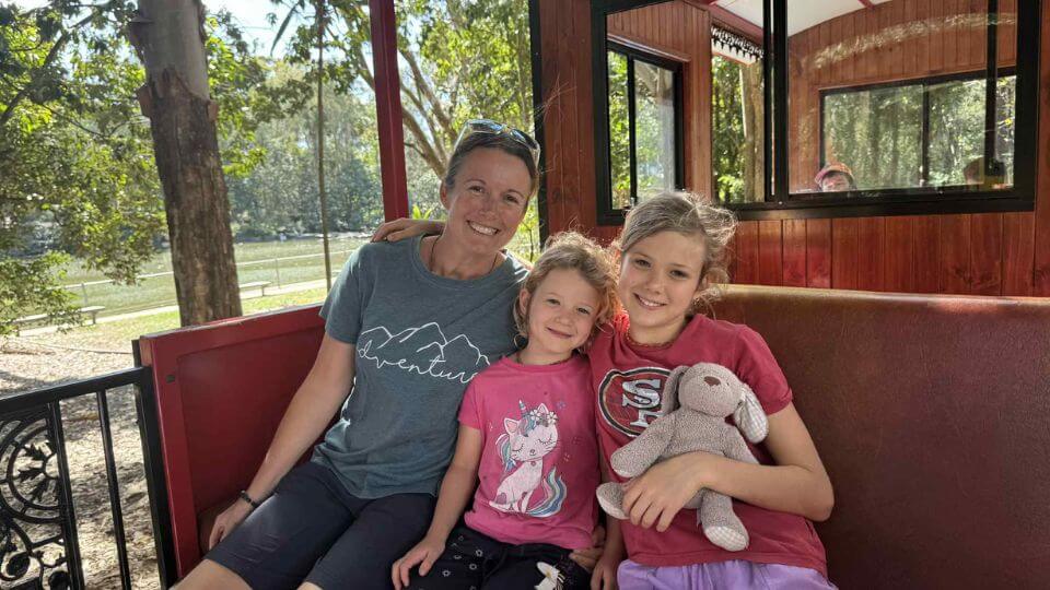 Elly, Romy, and Ayla ride the sugarcane railway train at the Bundaberg Botanic Gardens.