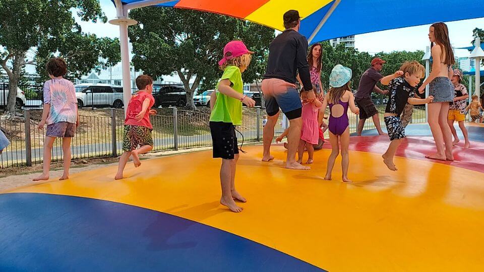 Romy and other kids on the jumping pilllow at Washington Waters Playground at Broadwater Parklands on the Gold Coast.