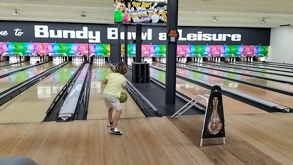 Romy rolling a bowling ball at Bundy Bowl and Leisure.