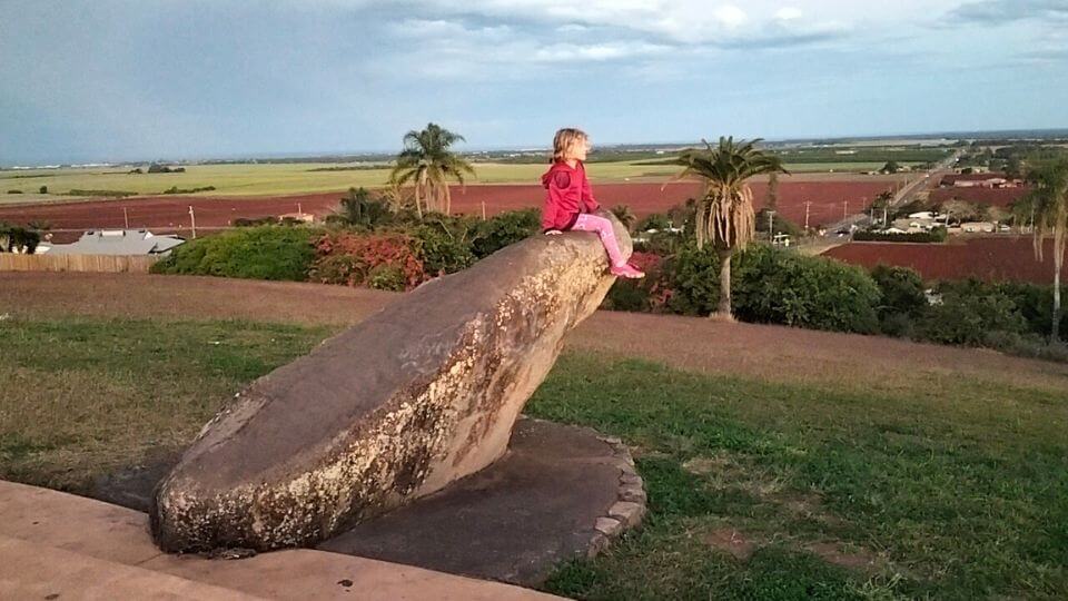 Romy sits on the edge of a big rock sculpture at the Hummock Lookout in Bundaberg.