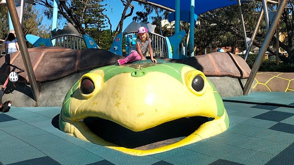 Romy sitting on the big turtle sculpture at the Turtle Park in Bargara.
