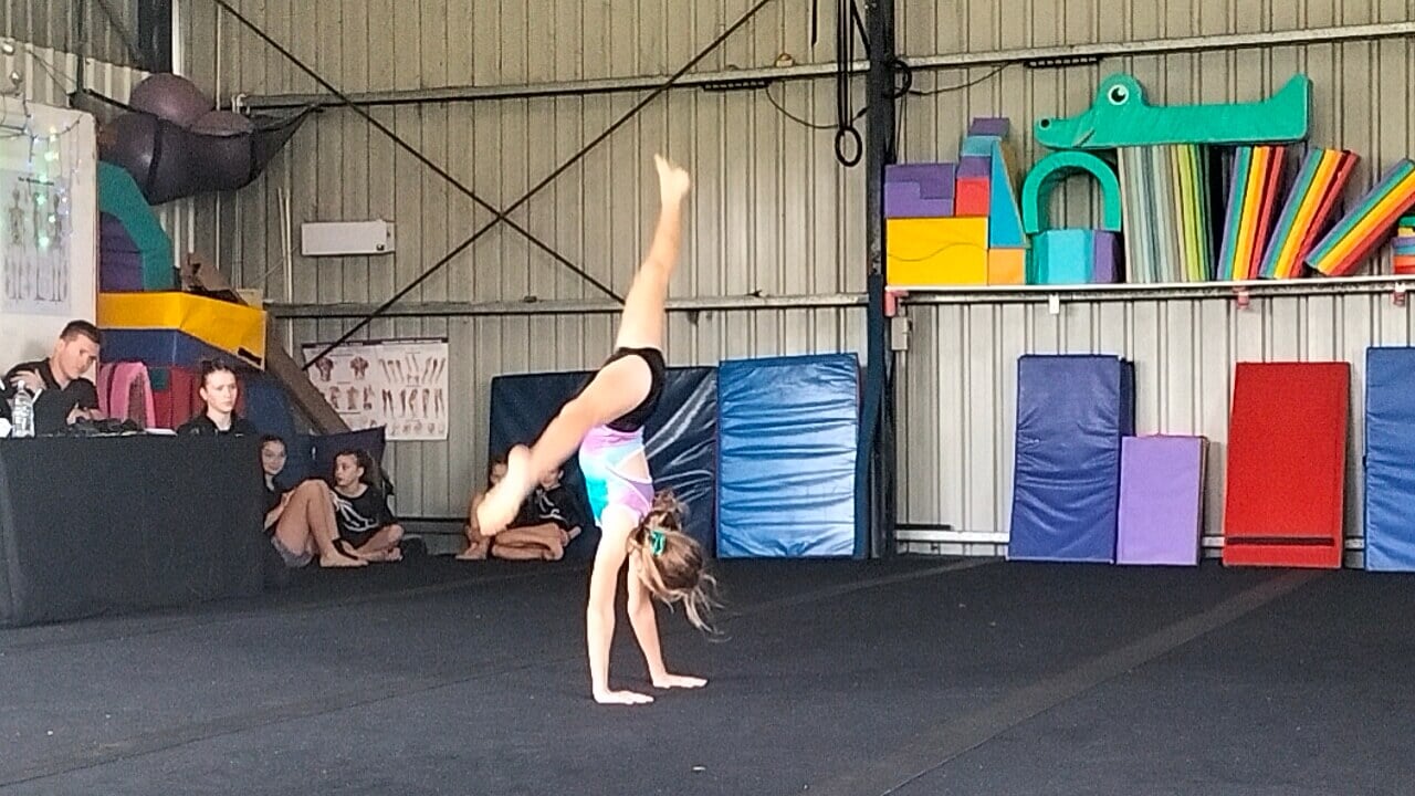 Ayla mid-cartwheel at an in-house gymnastics competition at Invert Sports Centre, Goulburn, NSW, Australia, 2025.