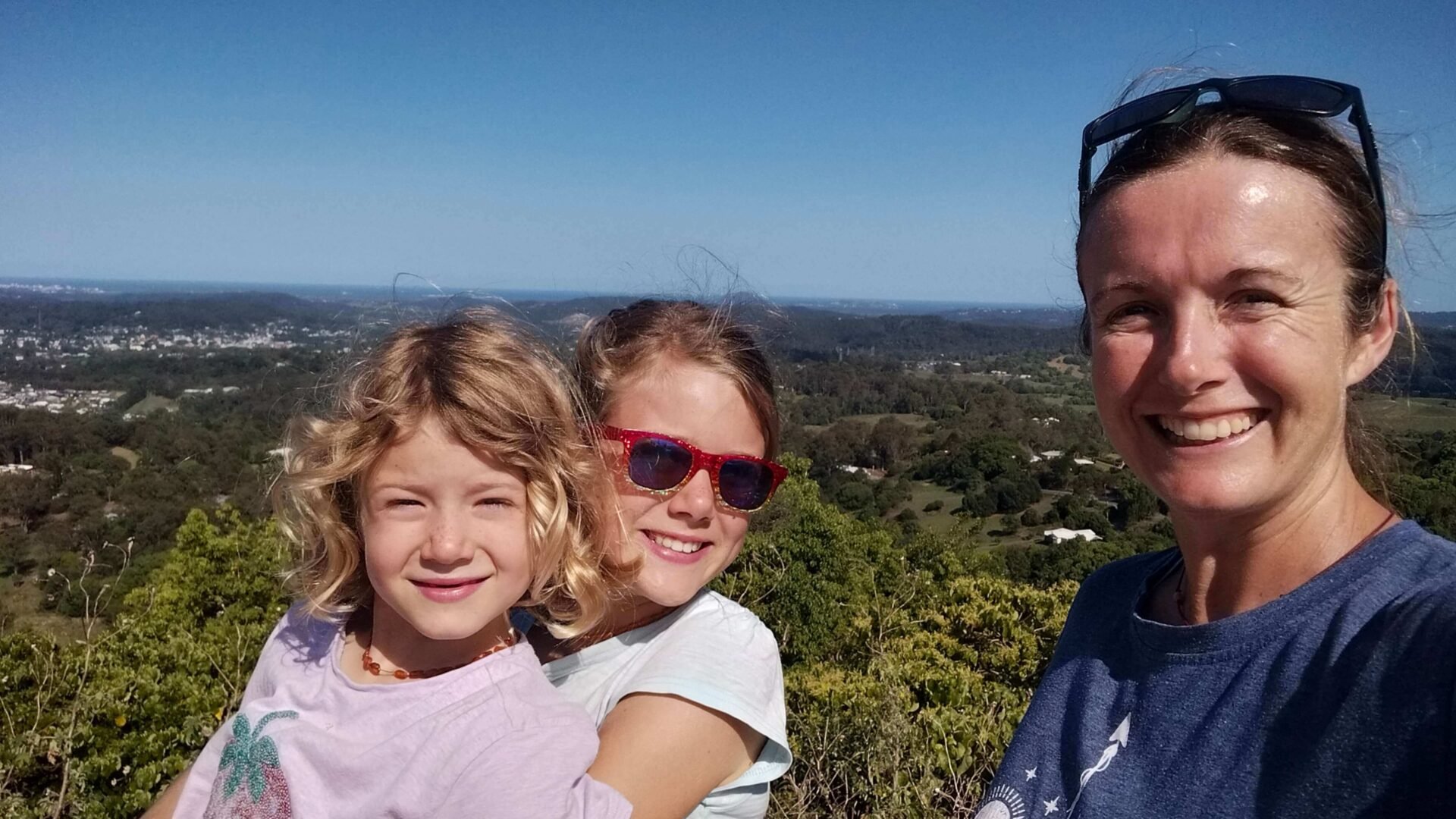 Romy, Ayla, and Elly at the Dulong Lookout near Nambour on a sunny day, with views of the Sunshine Coast Hinterland behind.