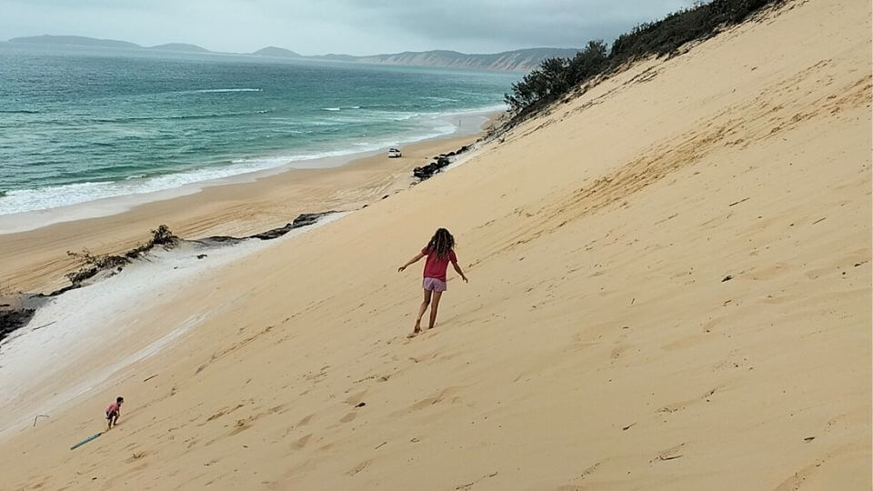 Ayla walks along the small sand blow cliffs at Rainbow Beach, a fantastic day trip from Gympie.
