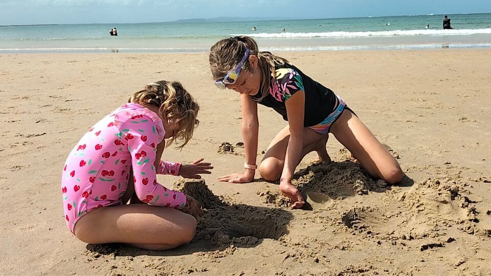 Romy and Ayla playing in the sand at Noosa Main Beach on the Sunshine Coast.