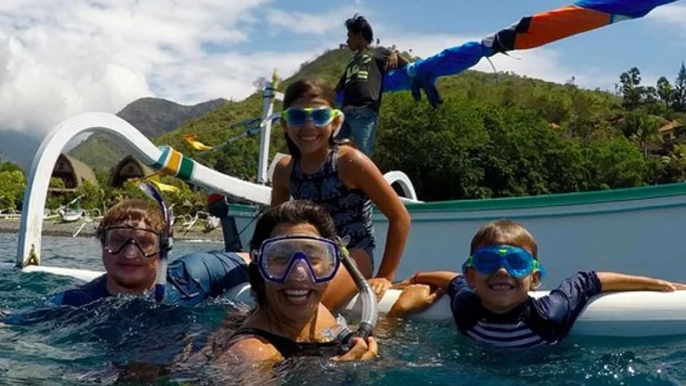 A family enjoys a morning of snorkeling in Ahmed during a three-day action-packed family retreat with Stoked Surf Bali.