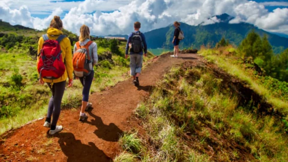 A family hikes up Mount Batur during an adventure retreat with Stoked Surf Bali.