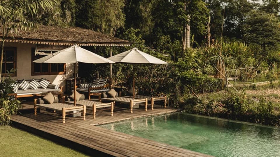 A pool and relaxation space at the Magia de Uma Heritage, a five-star boutique hotel in Canggu, where you will stay on your 4-day conscious parenting retreat.