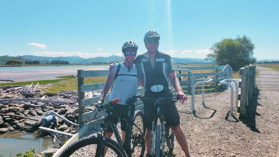 Elly and Colin stop for a photo on their bikes along the coastal Waipaoa River Trail in Gisborne, New Zealand.