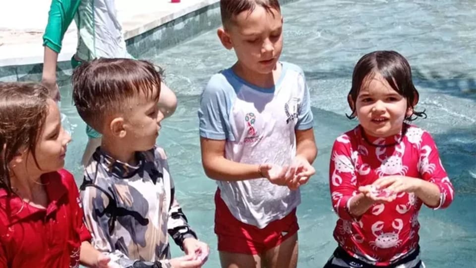 Kids enjoying their time in the swimming pool at Pronoia Resort in Jimbaran Bay, Bali, Indonesia.