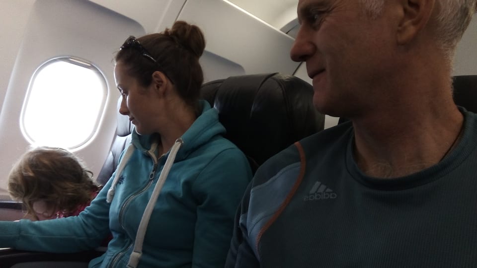 Ayla, Elly, and Colin seated on an airplane.