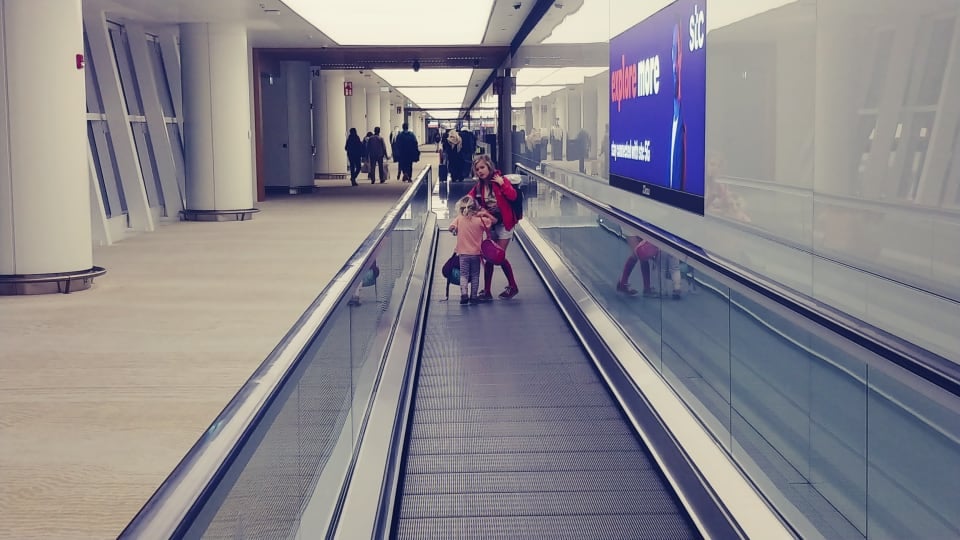Romy and Ayla on an airport travelator.