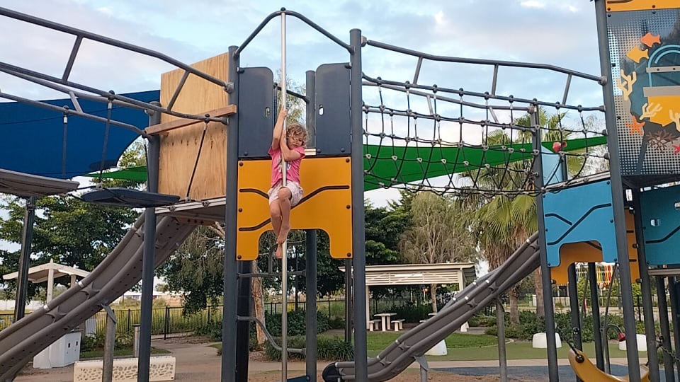 Romy slides down a pole at The Junction Park North Shore in Townsville.