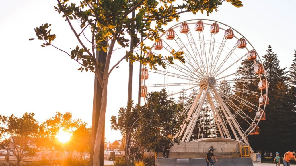 Vibrant ferris wheel beside a skatepark at sunset in Fremantle, WA, Australia.