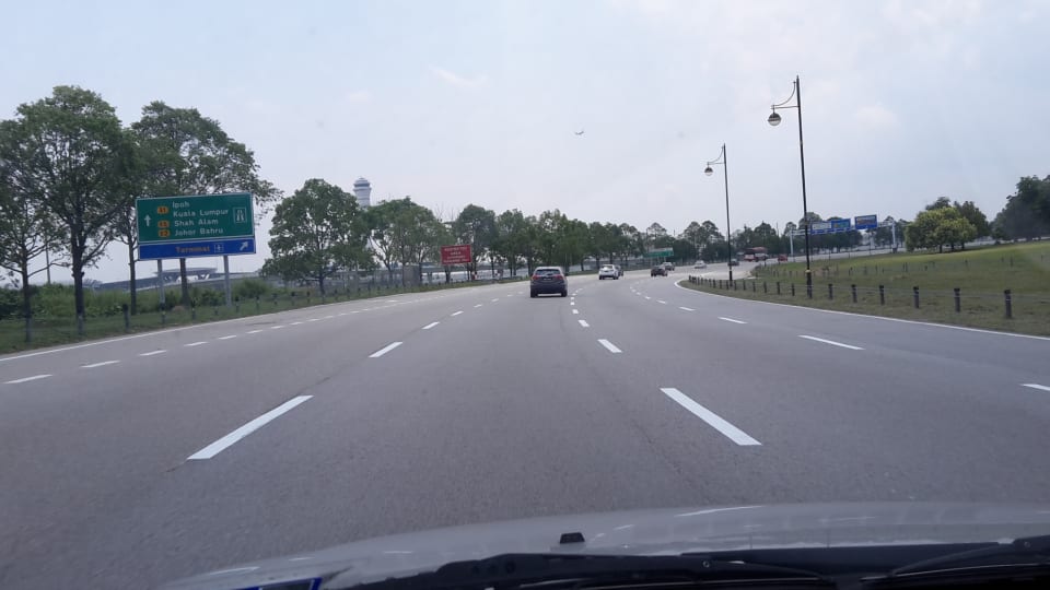 A view of a road as taken from the passenger seat of a car.