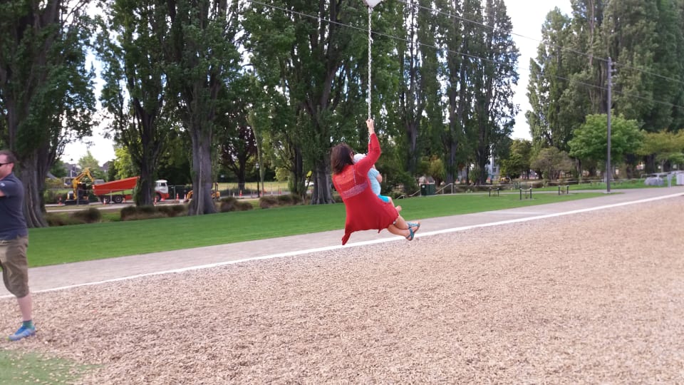 Ayla rides on the flying fox on a friend's lap at the Margaret Mahy Playground in Christchurch.