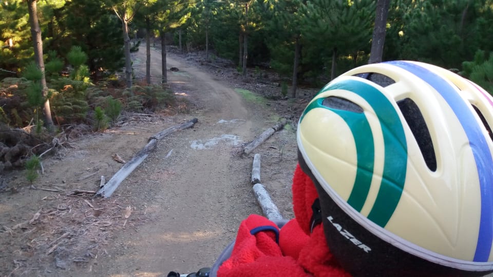 Ayla sits on a bike while mum rides at McLeans Island cycling area in Christchurch.