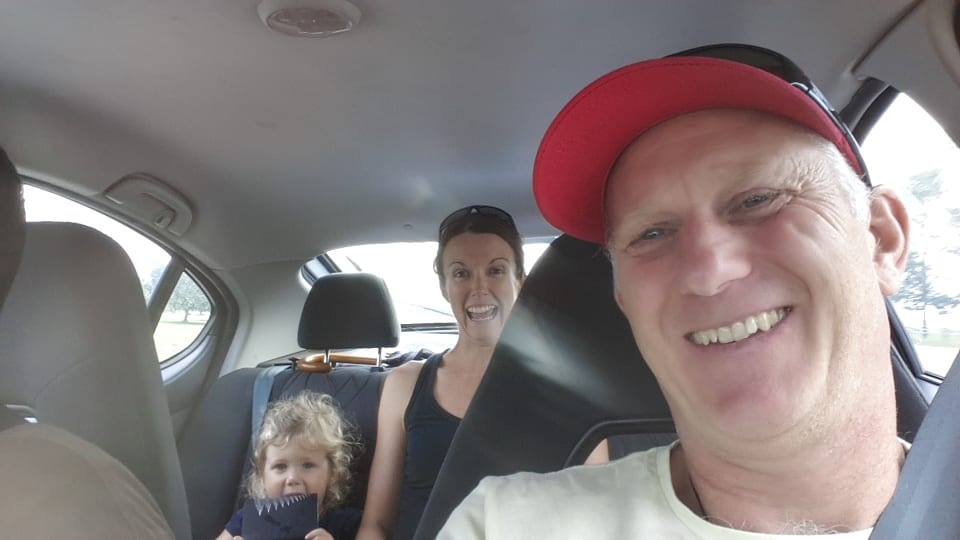 Colin, Elly, and Ayla selfie in a rental car in Malaysia.
