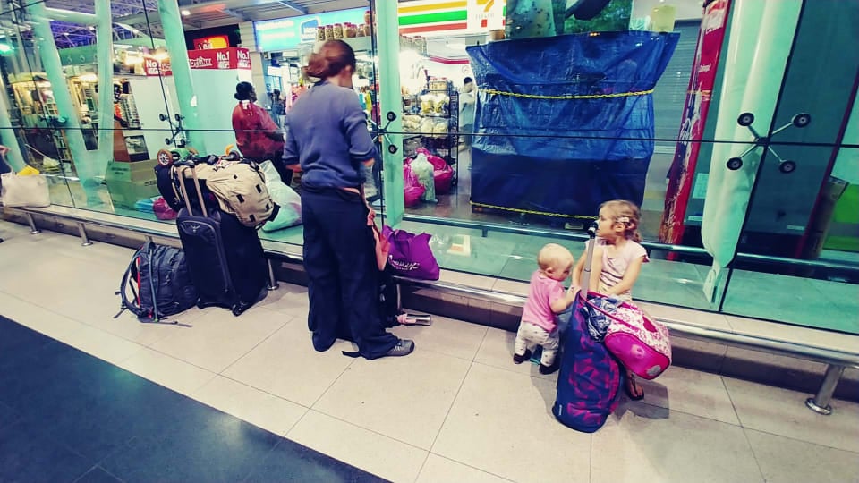 Elly, Ayla, and Romy with all their travel bags outside a station on a travel day.