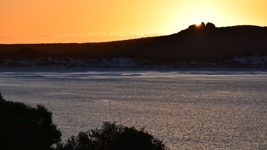 Serene sunrise over Cape Le Grand, capturing tranquil waters and golden hues.