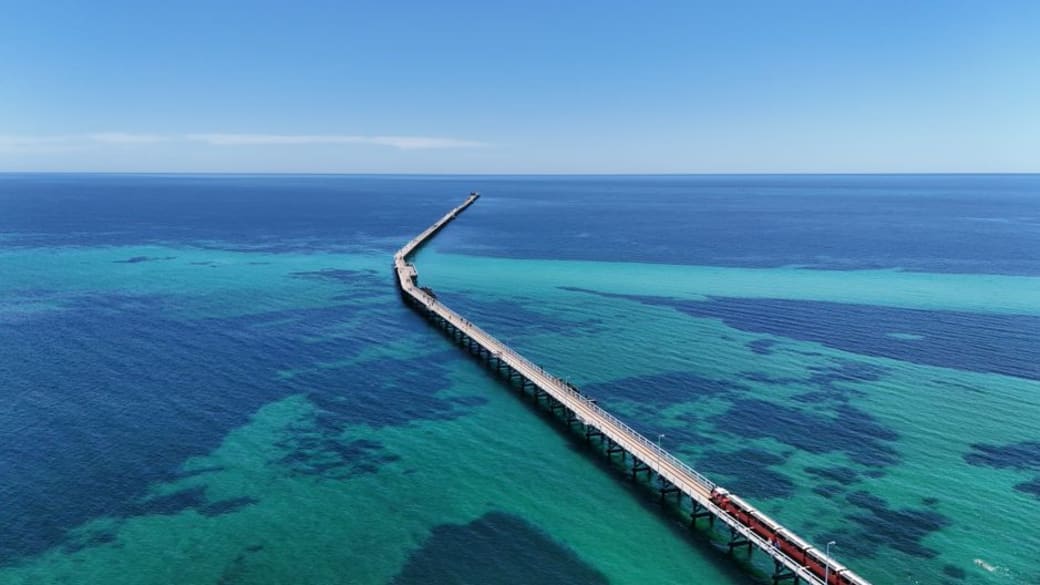 Stunning aerial view of Busselton Jetty extending over turquoise waters in Western Australia.