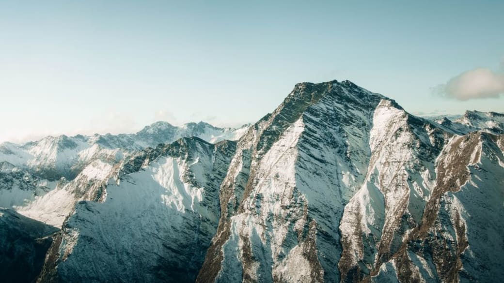 Aerial view of snow-covered mountains in Queenstown, New Zealand, showcasing breathtaking winter scenery.