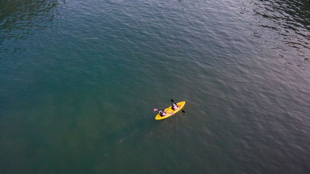 Aerial view of two kayakers paddling on calm, open water, enjoying a peaceful outdoor adventure.