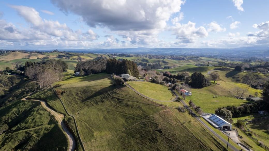 Aerial view showcasing lush farmland in Tauranga, Bay of Plenty, New Zealand under a clear sky.