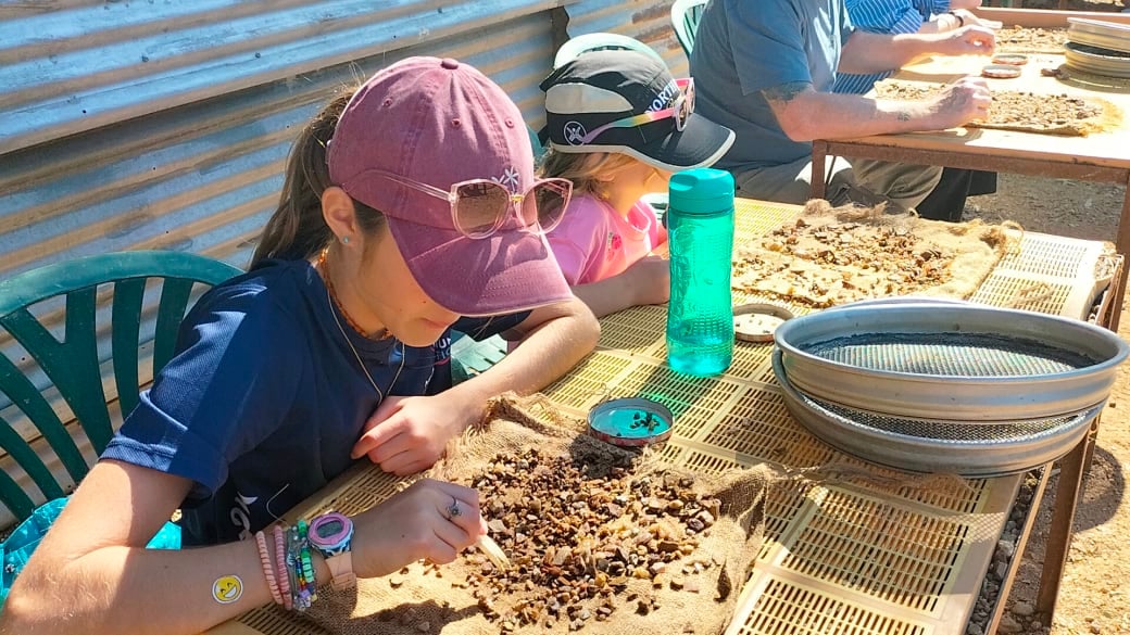 Ayla and Romy sorting through their wash, looking for gems at Pats Gems Tourist Fossicking Park and Cafe in Sapphire.