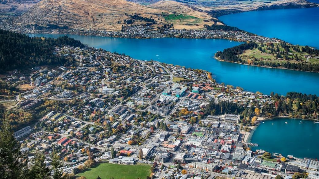 Breathtaking aerial view of Queenstown, New Zealand with lake and mountains.
